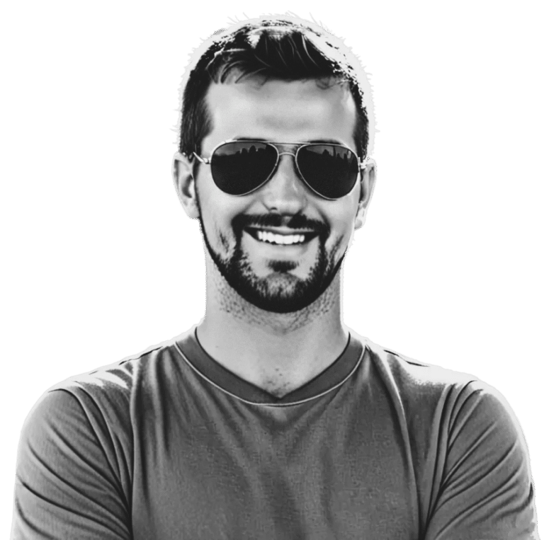 A man with a beard wearing sunglasses and a t-shirt smiles against a transparent background.